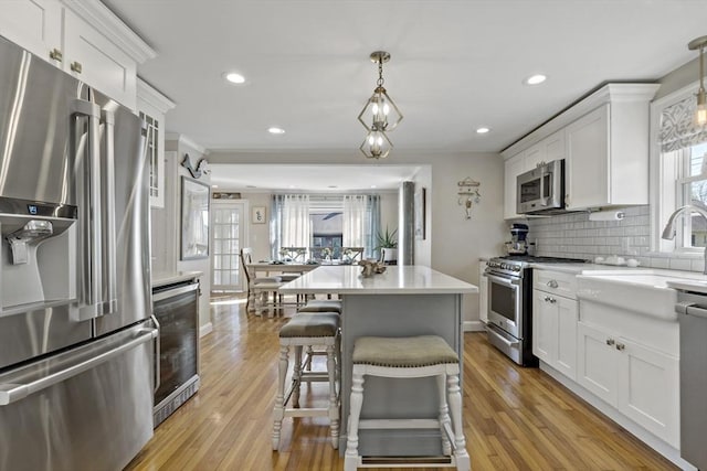 21 Grove St, Fairhaven, MA 02719 - kitchen with appliances with stainless steel finishes, a sink, white cabinets, backsplash, and recessed lighting