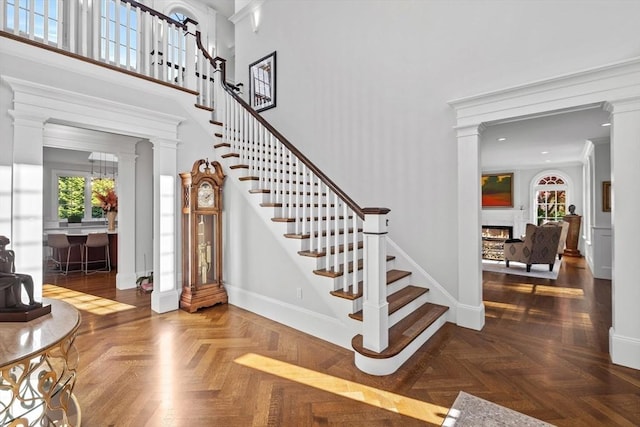 37 Radcliffe Rd, Newton, MA 02468 - interior space featuring decorative columns, a lit fireplace, baseboards, a high ceiling, and recessed lighting