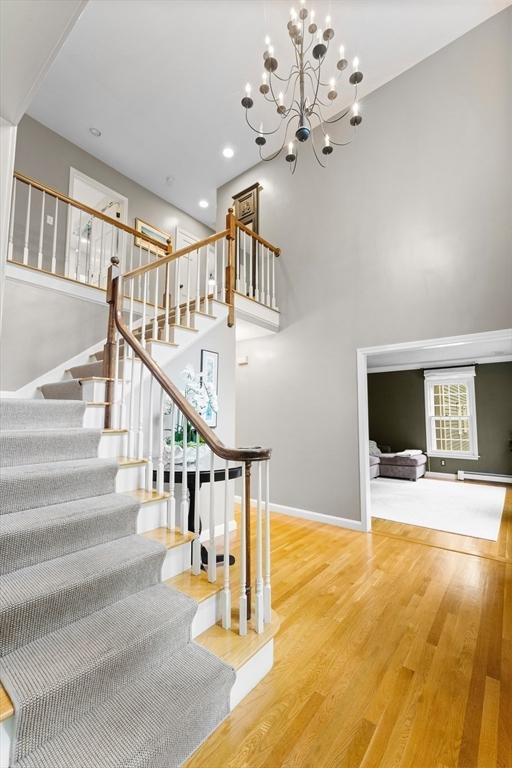 126 Arrow Head Rd, Marshfield, MA 02050 - stairs featuring a high ceiling, wood finished floors, baseboards, a chandelier, and recessed lighting