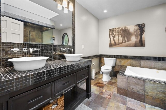 126 Arrow Head Rd, Marshfield, MA 02050 - full bathroom with stone tile flooring, tiled bath, tiled shower, toilet, and double vanity