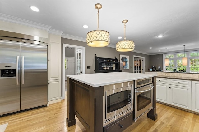 126 Arrow Head Rd, Marshfield, MA 02050 - kitchen with built in appliances, light countertops, white cabinetry, light wood-style flooring, and recessed lighting