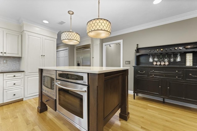 126 Arrow Head Rd, Marshfield, MA 02050 - kitchen featuring built in appliances, white cabinetry, light wood-type flooring, tasteful backsplash, and crown molding
