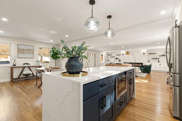 kitchen featuring open floor plan, plenty of natural light, freestanding refrigerator, and built in microwave