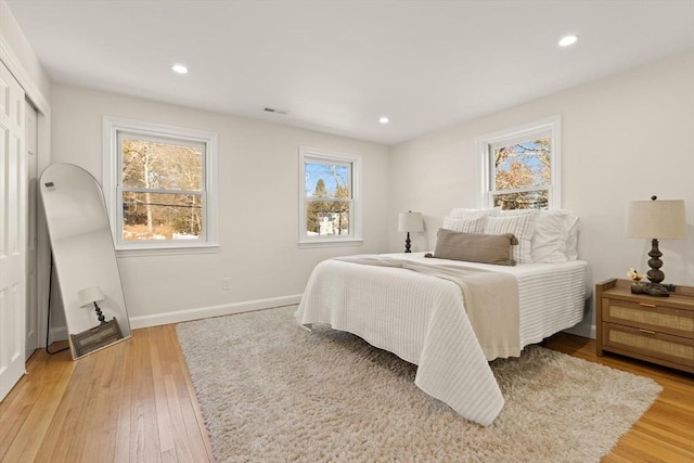 bedroom featuring baseboards, light wood-type flooring, visible vents, and recessed lighting