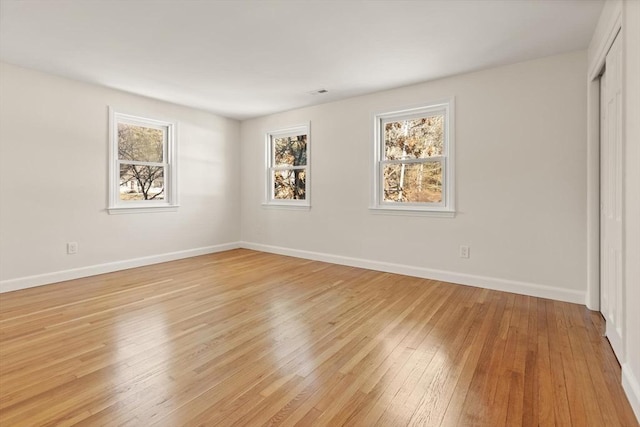 unfurnished bedroom featuring light wood finished floors, a closet, and baseboards