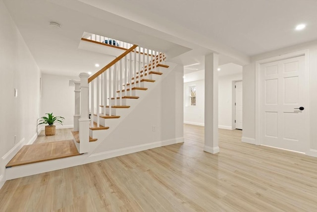 interior space with stairs, wood finished floors, and baseboards