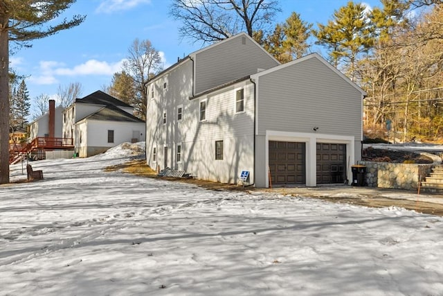 view of snow covered exterior featuring a garage