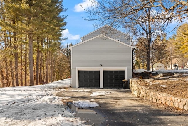 view of side of home featuring a garage and concrete driveway