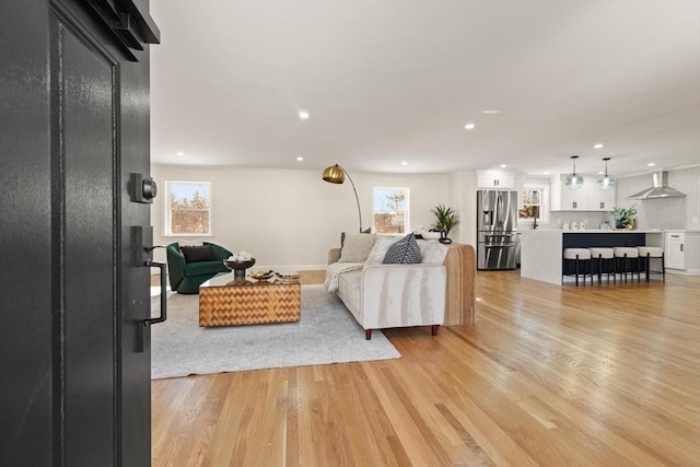 living area with light wood-style flooring and recessed lighting