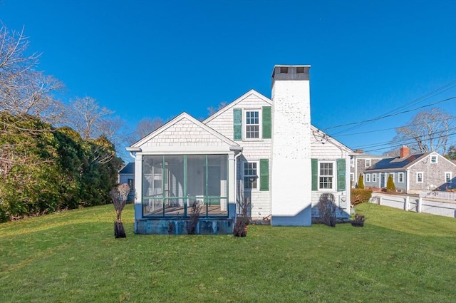 rear view of property with a sunroom and a yard