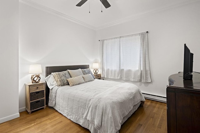 bedroom featuring baseboard heating, ceiling fan, ornamental molding, and hardwood / wood-style flooring