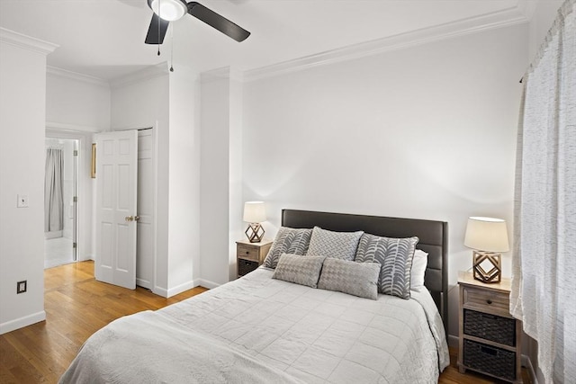 bedroom with hardwood / wood-style flooring, ceiling fan, and ornamental molding