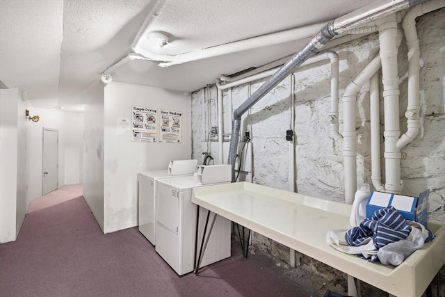 laundry room featuring washing machine and dryer, carpet, and a textured ceiling