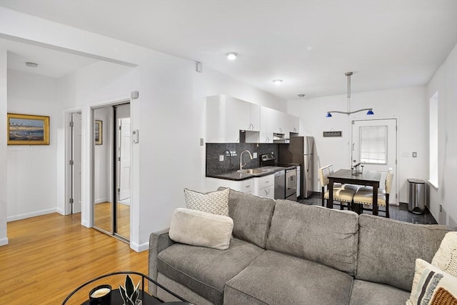 living room featuring light hardwood / wood-style floors and sink