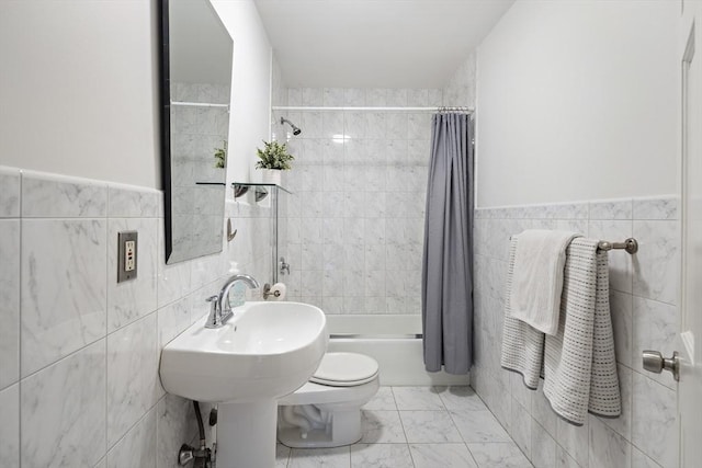 bathroom featuring toilet, tile walls, and shower / bath combo with shower curtain