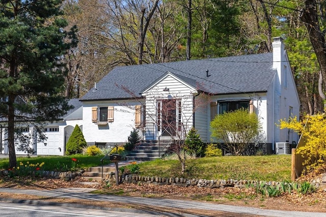 view of front of house with a garage, central air condition unit, a chimney, and roof with shingles