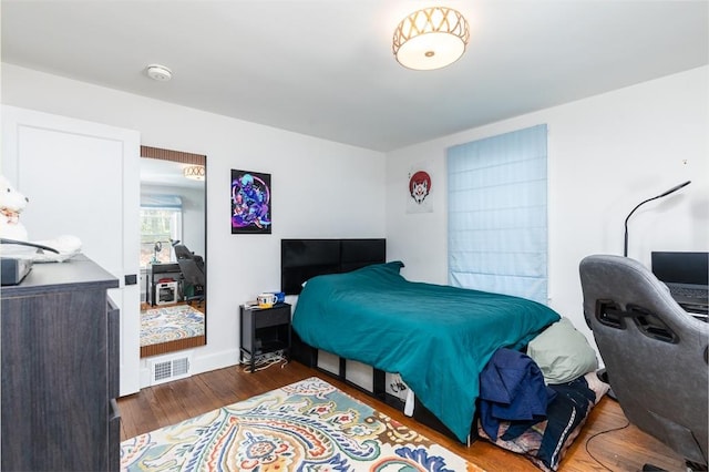 bedroom with wood finished floors and visible vents