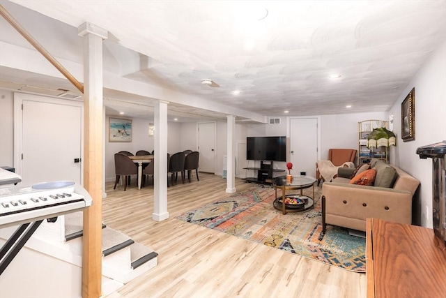 living area with decorative columns, recessed lighting, wood finished floors, and visible vents