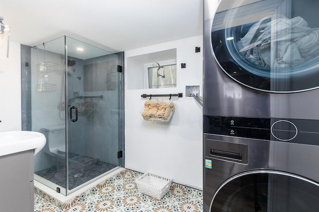 full bath featuring stacked washer / drying machine, a shower stall, tile patterned floors, and vanity