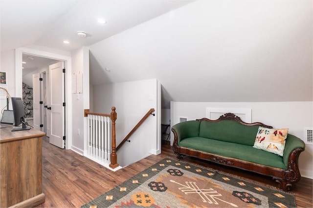 sitting room featuring visible vents, an upstairs landing, wood finished floors, and vaulted ceiling