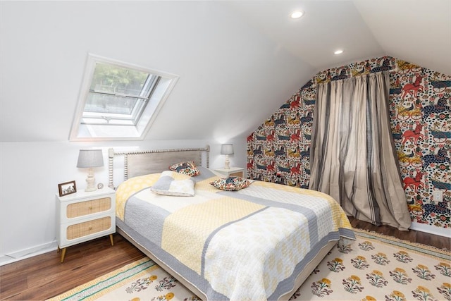bedroom featuring vaulted ceiling with skylight, baseboards, recessed lighting, and wood finished floors
