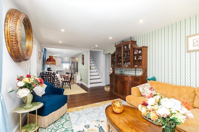 living room with stairs, baseboards, wallpapered walls, dark wood-type flooring, and recessed lighting