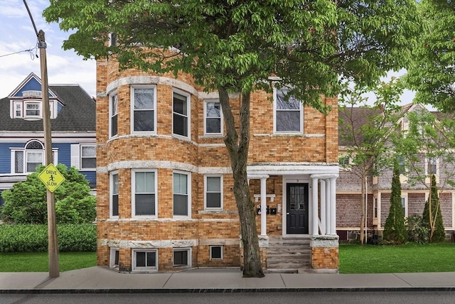 view of front of property featuring a front yard and brick siding