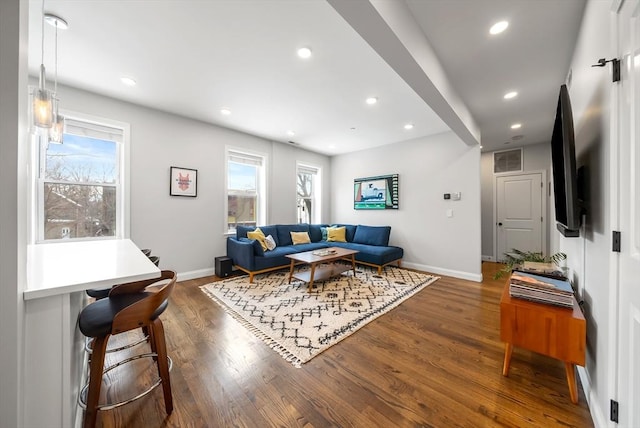 living area featuring baseboards, dark wood finished floors, visible vents, and recessed lighting