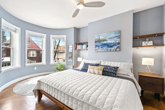 bedroom with ceiling fan, baseboards, and wood finished floors