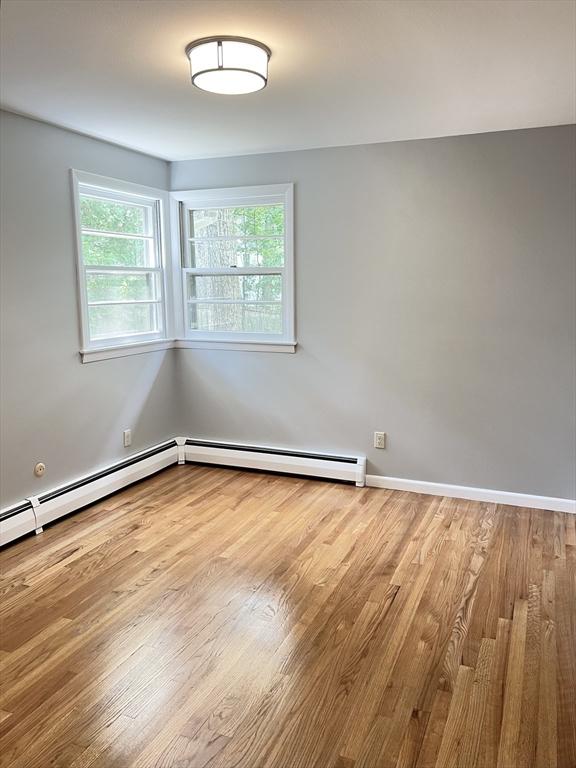 216 Bel Air Dr, Longmeadow, MA 01106 - empty room with wood finished floors and a baseboard heating unit