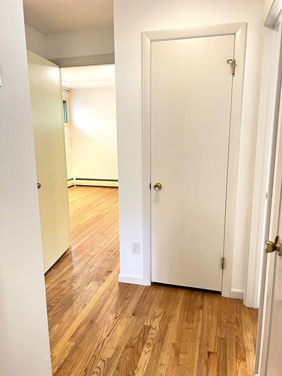 216 Bel Air Dr, Longmeadow, MA 01106 - hallway with a baseboard radiator and wood finished floors