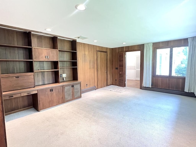 216 Bel Air Dr, Longmeadow, MA 01106 - unfurnished living room with wooden walls, recessed lighting, a baseboard heating unit, built in study area, and light carpet