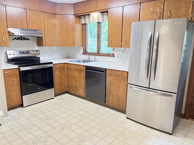 216 Bel Air Dr, Longmeadow, MA 01106 - kitchen with appliances with stainless steel finishes, under cabinet range hood, light countertops, brown cabinetry, and light flooring