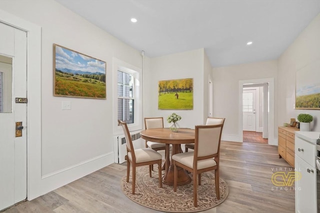 dining space featuring radiator heating unit and light hardwood / wood-style flooring