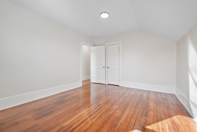 interior space featuring wood-type flooring and vaulted ceiling