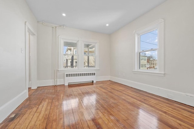 unfurnished room featuring radiator heating unit and wood-type flooring