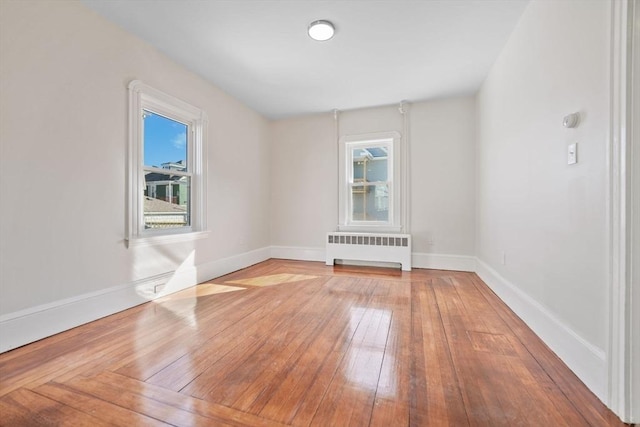 spare room with radiator and hardwood / wood-style floors