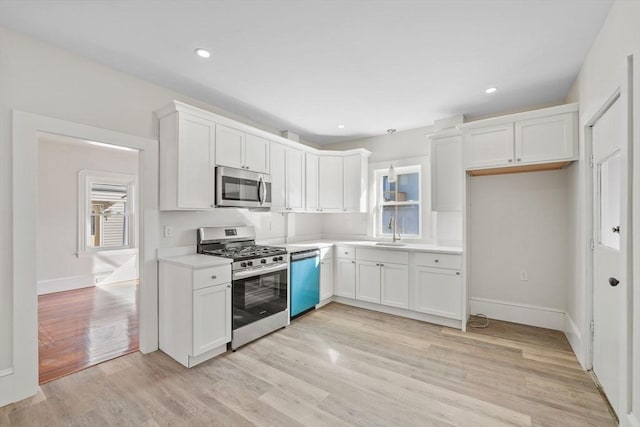 kitchen with white cabinetry, sink, light hardwood / wood-style flooring, and stainless steel appliances