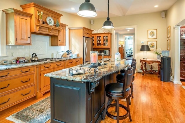 9 Mohawk Rd, Marblehead, MA 01945 - kitchen with a breakfast bar area, appliances with stainless steel finishes, light wood-style floors, light stone counters, and recessed lighting