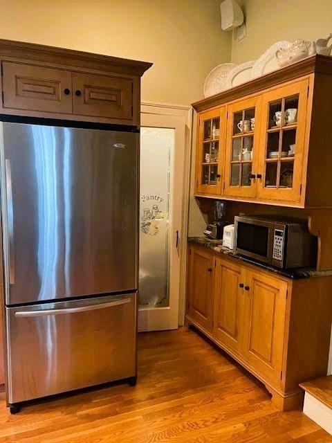 9 Mohawk Rd, Marblehead, MA 01945 - kitchen featuring appliances with stainless steel finishes, glass insert cabinets, light wood-style flooring, and brown cabinets
