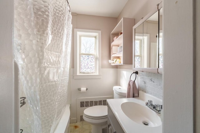 full bathroom with toilet, radiator heating unit, vanity, shower / bath combo, and decorative backsplash