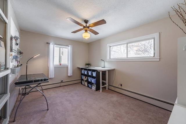 misc room featuring light carpet, ceiling fan, a baseboard radiator, and a textured ceiling