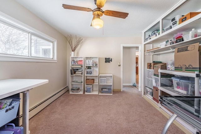 carpeted home office with ceiling fan and a baseboard heating unit