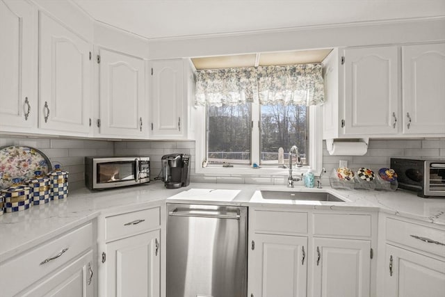 kitchen with a toaster, a sink, white cabinetry, appliances with stainless steel finishes, and backsplash