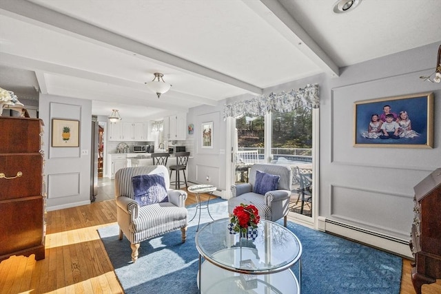 living room featuring light wood-type flooring, baseboards, beamed ceiling, and baseboard heating