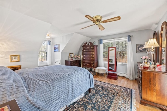 bedroom with ceiling fan, vaulted ceiling, and wood finished floors