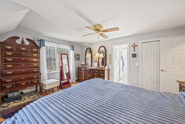 bedroom with lofted ceiling, a closet, wood finished floors, and a ceiling fan