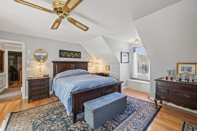 bedroom featuring a ceiling fan, vaulted ceiling, and wood finished floors