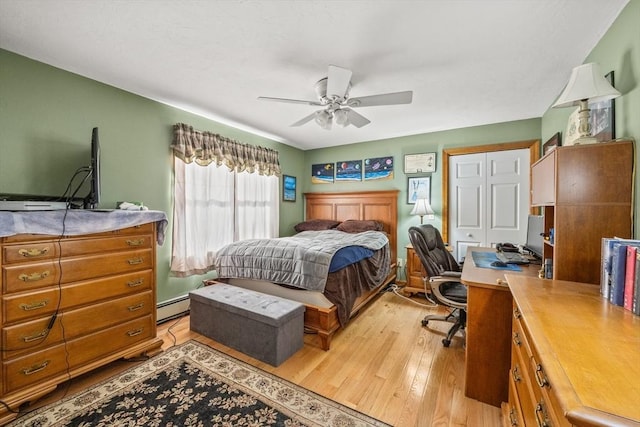 bedroom featuring ceiling fan, light wood finished floors, and a baseboard radiator