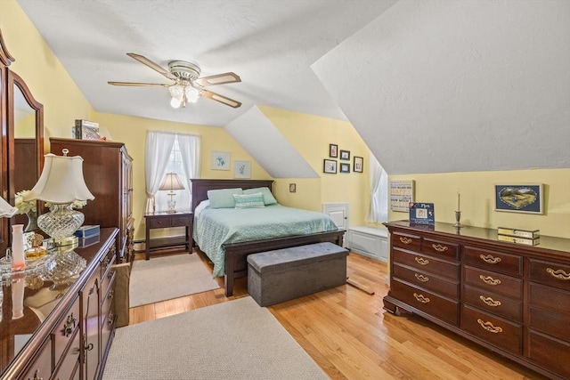 bedroom featuring light wood-type flooring, ceiling fan, and vaulted ceiling